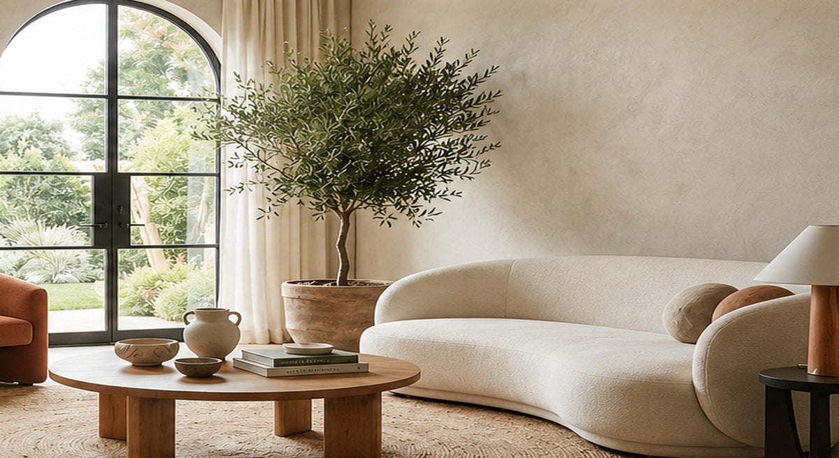 Warm luxury living room with arched garden doors, an olive tree, and a curved cream sofa